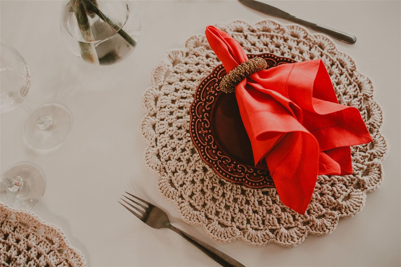 Hand-crocheted table setting with a red napkin