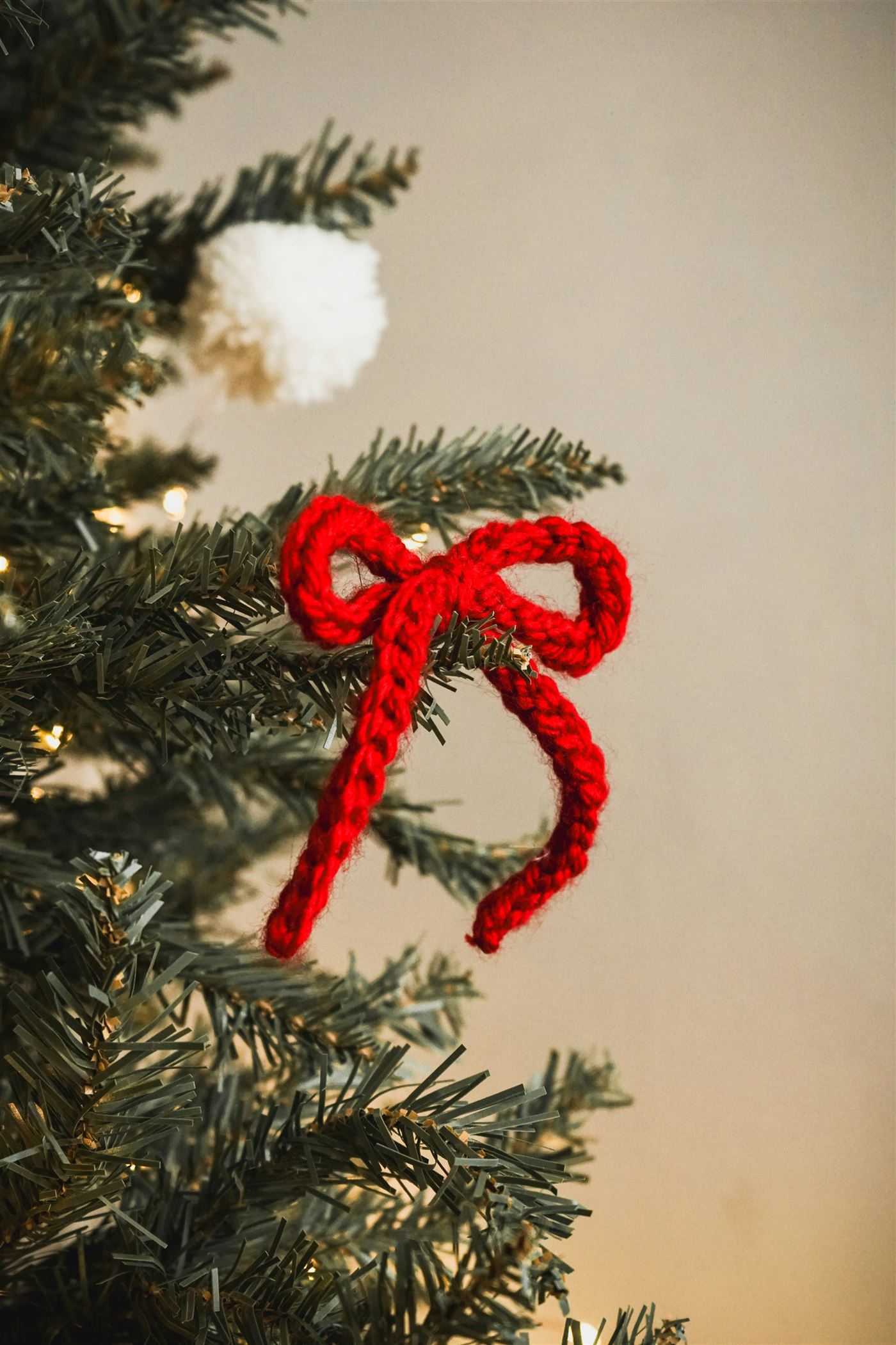 Hand-crocheted red bow decorating a festive tree